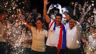 根据官方初步计票显示，巴拉圭执政党红党赢得总统选举。代表改党的候选人佩纳（中）当地时间周日晚，与妻子和竞选搭档阿利亚纳在该党位于首都亚松森的总统庆祝。（图取自路透社）
