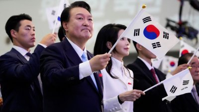 韩国总统尹锡悦周二在庆祝国家摆脱日本殖民统治78周年纪念仪式上致辞后，与一众与会者挥舞著韩国国旗。（图取自路透社）