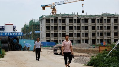 8月18日在中国天津，工人们步出中国开发商碧桂园的住宅建筑工地。（图取自路透社）