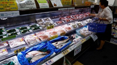 一名顾客8月31日在日本福岛县相马市的Hamanoeki鱼市场和美食广场，选购当地捕获的海鲜。（图取自路透社）
