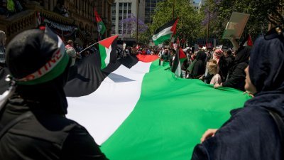 10月21日在澳洲悉尼举行的声援巴勒斯坦人集会上，参与的民众们除挥舞著巴勒斯坦旗帜，也展开一面大幅的巴勒斯坦旗帜。（图取自AAP/路透社）