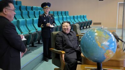 朝鲜官媒于上周六发布照片，显示朝鲜最高领导人金正恩访问国家航空航天技术局平壤总控制中心，仔细检视卫星发送回来的照片。（图取自朝中社/路透社）