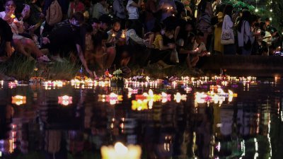 泰国曼谷民众11月27日庆祝水灯节，将用树叶和鲜花制成的篮子放在公园潟湖中。（图取自路透社）