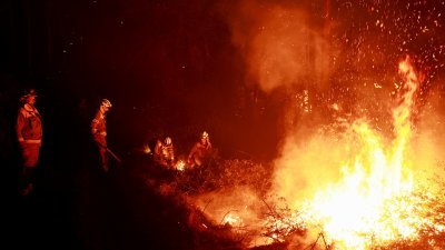 西班牙加利西亚的消防员，周五在阿斯图里亚斯试图扑灭野火。（图取自路透社）