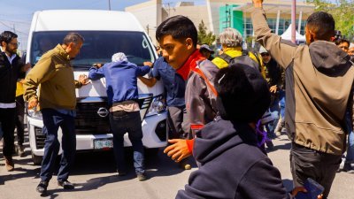 墨西哥总统洛佩斯座车周五在华雷斯城遭大批移民包围。（图取自路透社）