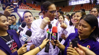 巴育（中）和他所属的泰国人团结建国党议员候选人及支持者，周一在曼谷的体育馆造势时与采访的记者们互动。（图取自路透社）