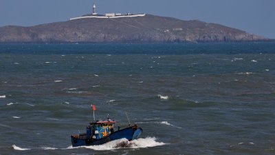 周日，一艘中国渔船穿过台湾海峡，在福建省平潭岛外的牛山岛附近航行。（图取自路透社）