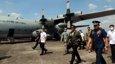 菲律宾总统马科斯3月31日（前排右3，戴墨镜）在邦板牙克拉克空军基地，视察一架由美国通过“外国军购计划”赠送的C-130T特种空降任务安装和响应 (SABIR) 飞机。（图取自总统摄影师协会/法新社）