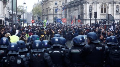 在法国宪法委员会于当地时间周五通过退休制度改革法案核心内容后，警方在巴黎市政厅外的示威活动中就位。（图取自路透社）