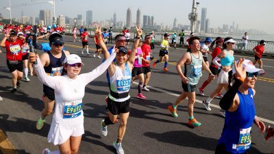 2023年武汉马拉松周日早鸣枪开跑，参赛选手奔跑在武汉长江大桥赛道上。 （图取自中新社）