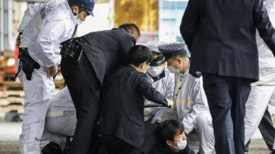 日本专家指出，对首相岸田文雄丢掷爆裂物的犯嫌木村隆二（图中黑衣者）可能是安倍晋三遇刺案的模仿犯。（图取自共同社/路透社）