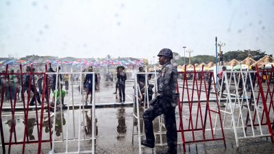 4月9日至17日为缅甸泼水节和新年连假，上周四警察在仰光的某庆祝活动中站岗。（图取自法新社）