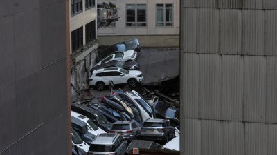 纽约市曼哈顿区一个停车场倒塌后，汽车和倒塌的混凝土板中堆叠在一起。（图取自路透社）