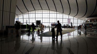 旅客推著行李，走过北京大兴国际机场大堂。（图取自路透社）