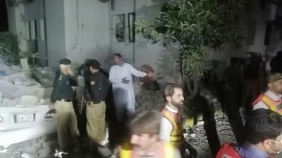 巴基斯坦开伯尔-普什图省斯瓦特河谷一个反恐中心弹药库发生爆炸后，警员和救援人员聚集在现场。（图取自救援1122/路透社）