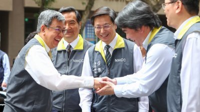 台湾行政院长陈建仁（左）周二前往视察中央流行疫情指挥中心，与指挥官王必胜（右2）握手致意。（图取自中央社）