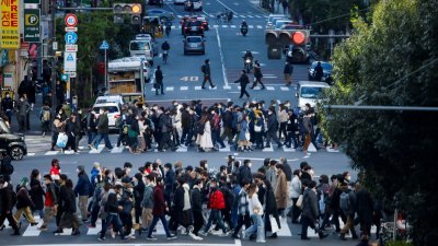 日本首都东京的街头，行人走在斑马线上越过马路。（图取自路透社）