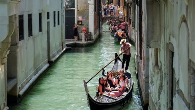 是意大利威尼斯特有和最具代表性的传统划船，船夫划著贡多拉带游客穿过威尼斯运河。（路透社档案照）