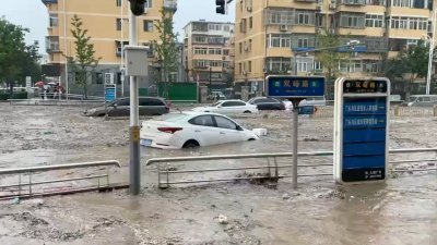受台风“杜苏芮”影响，中国北京门头沟区的街道，周一遭强降雨引发的洪涝淹没。（图取自路透社）