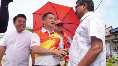 黄瑞林（中）向选民拜票时，吁选民共同守护适耕庄，左为霹雳州行政议员吴家良。