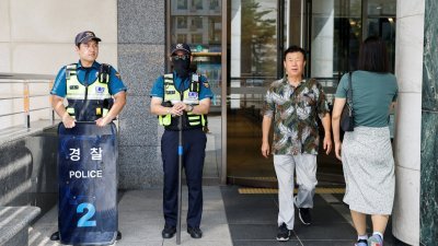 8月3日发生随机袭击事件的京畿道城南市盆唐一家商场外，有警员驻守，保护民众安全。（图取自路透社）