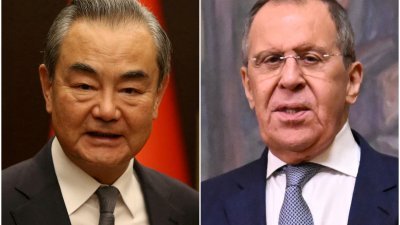 中国外交部长王毅（左）周一与俄罗斯外长拉夫罗夫通电话，谈及乌克兰危机问题。（图取自路透社）
