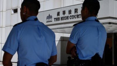 在禁止2019年抗议歌曲《愿荣光归香港》的禁令听证会之前，警方7月21日在高等法院外守卫。（图取自路透社）
