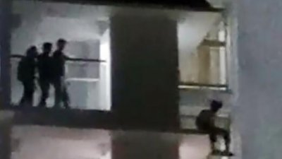 青年坐在楼梯间的墙沿上闹跳楼，不断大喊大叫，和民防人员僵持近两小时后被救下。