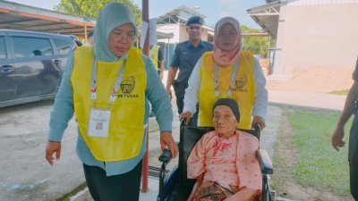 108岁女人瑞穆娜雅丹尽管无法行走，仍履行选民责任，前往投票。（图取自《马来西亚前锋报》）