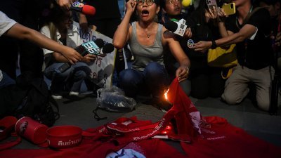 亲民主组织不满为泰党违背竞选承诺，周五傍晚聚集在为泰党总部外示威，并燃烧印有塔辛和英叻肖像的衣服。（图取自路透社）