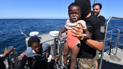 试图逃往欧洲的非洲移民周四受困在突尼斯和意大利之间的海域，突尼斯海岸警卫队救起他们，转移到一艘更大的船。（图取自法新社）