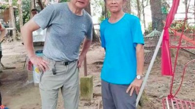 王毅现身峇都丁宜自由山，与一名登山友合照。（图取自网络）