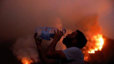 西班牙加那利群岛特内里费岛的野火接近失控，居民周四搬走家中的重要物品，并紧急撤离。（图取自路透社）