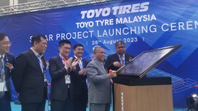 沙拉尼（前排左4）为东洋轮胎马来西亚有限公司，举办的全霹雳规模最大的屋顶太阳能项目投资主持启动仪式后，在纪念板上签名。