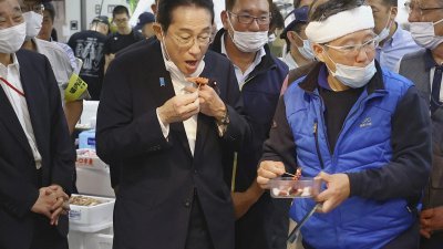 日本首相岸田文雄周四在参观东京丰洲鱼市场时品尝福岛地区的海鲜。（图取自共同社/路透社）