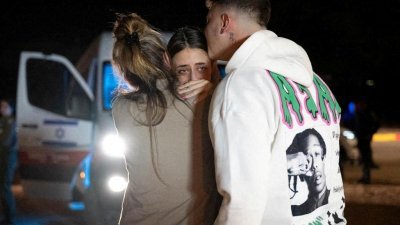 21岁的沙姆（Mia Schem）当地时间周四获释后，在以色列哈泽里姆军事基地与久别重聚的家人拥抱。（图取自以色列总理办公室/路透社）