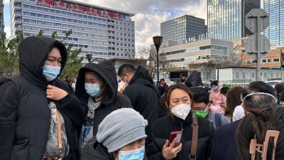 中国呼吸道疾病激增和儿童聚集性肺炎，北京一家儿童医院外聚集了大批孩子和家长。（图取自路透社）