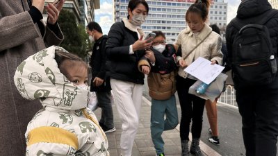 中国流感、肺炎支原体感染活动增强，首都医科大学附属北京儿童医院外有不少家长带著孩子求医。（图取自路透社）