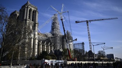 巴黎圣母院重建持续赶工，修复工人在新的木质结构尖顶周围脚架上工作。（图取自法新社）