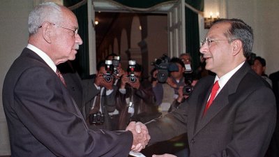 2000年8月3日，罗查（右）在拉巴斯的玻利维亚总统府宣誓就任后，与当时的玻利维亚总统班塞尔握手。（图取自路透社）