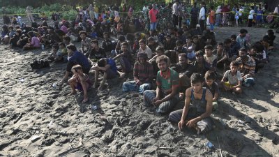 在周日登陆印尼亚齐省皮迪(Pidie)的缅甸罗兴亚穆斯林在沙滩上休息。（图取自路透社）
