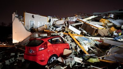 美国田纳西州亨德森维尔当地时间周六（9日）遭受龙卷风袭击后，一辆汽车被埋在主街上的废墟下。（图取自USA Today Network/路透社）