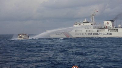 根据菲律宾海岸防卫队周日公布的照片，一艘中国海警艇在南沙群岛仁爱礁邻近海域向菲方的补给船使用高压水炮。（图取自菲律宾海岸防卫对/路透社）
