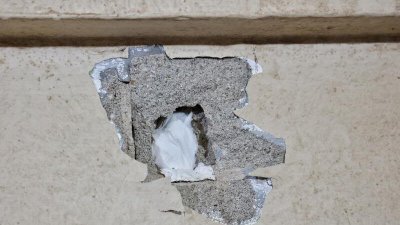 墙壁被敲破后掉落了许多碎片。