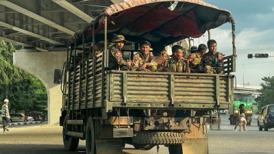 在缅甸最大城市仰光，一辆载著军方人员的军车在大街上巡逻。（图取自法新社）