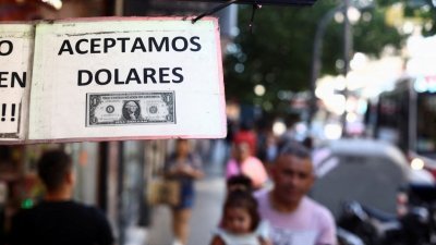 在阿根廷布宜诺斯艾利斯，一家商店外的标志上写著“我们接受美元”。（图取自路透社）