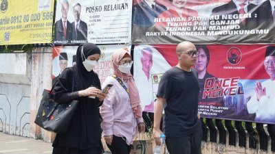 印尼首都雅加达街头有许多民众再次戴起口罩，部分是因为空污，但也有人是担心确诊感染。（图取自中央社）