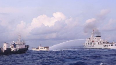菲律宾当局12月10日发布照片，一艘中国海警船（右）在南中国海有主权争议的仁爱礁使用高压水枪攻击菲方的补给船。（图取自菲律宾海岸防卫队（PCG）/法新社）