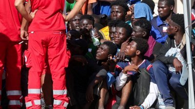 9月17日在意大利西西里兰佩杜萨岛，非法移民聚集在移民接待中心。（图取自路透社档案照）