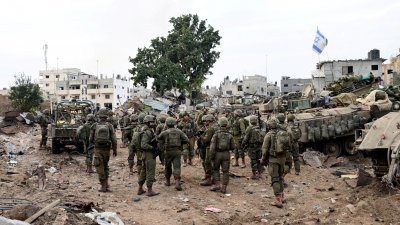 图为12月8日，以色列士兵在加沙市沙贾亚区执行任务。（图取自路透社）